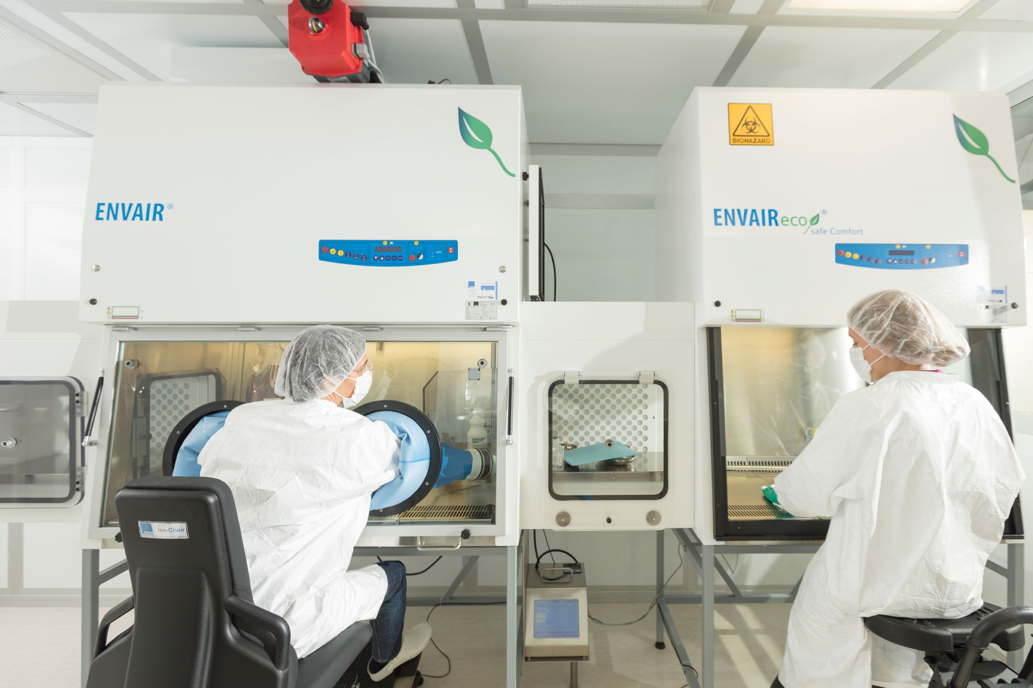 Zwei Mitarbeiter*innen in steriler Schutzkleidung am Isolator