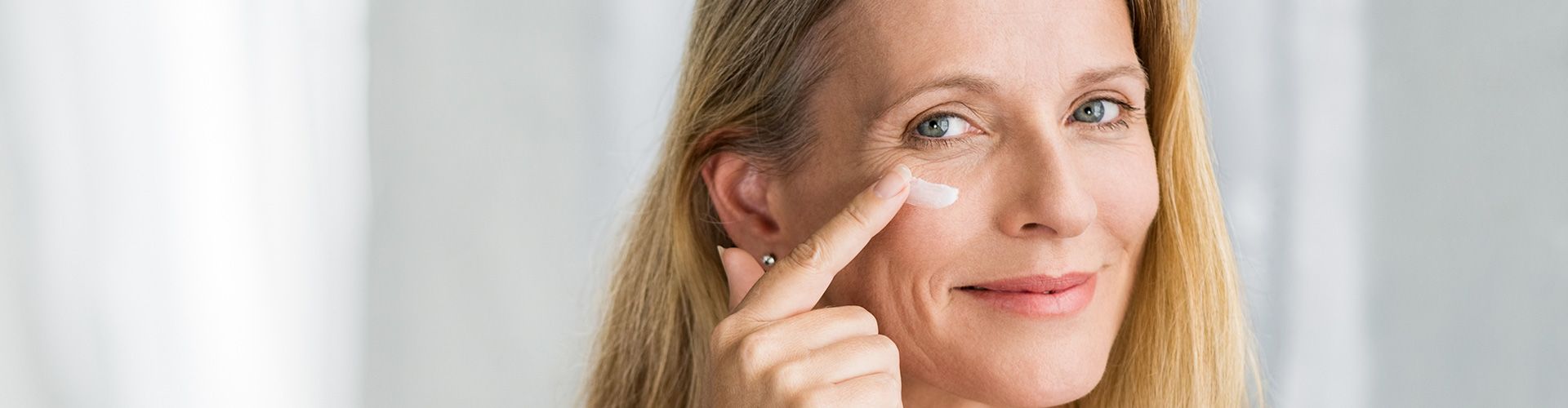 Frau cremt ihr Gesicht